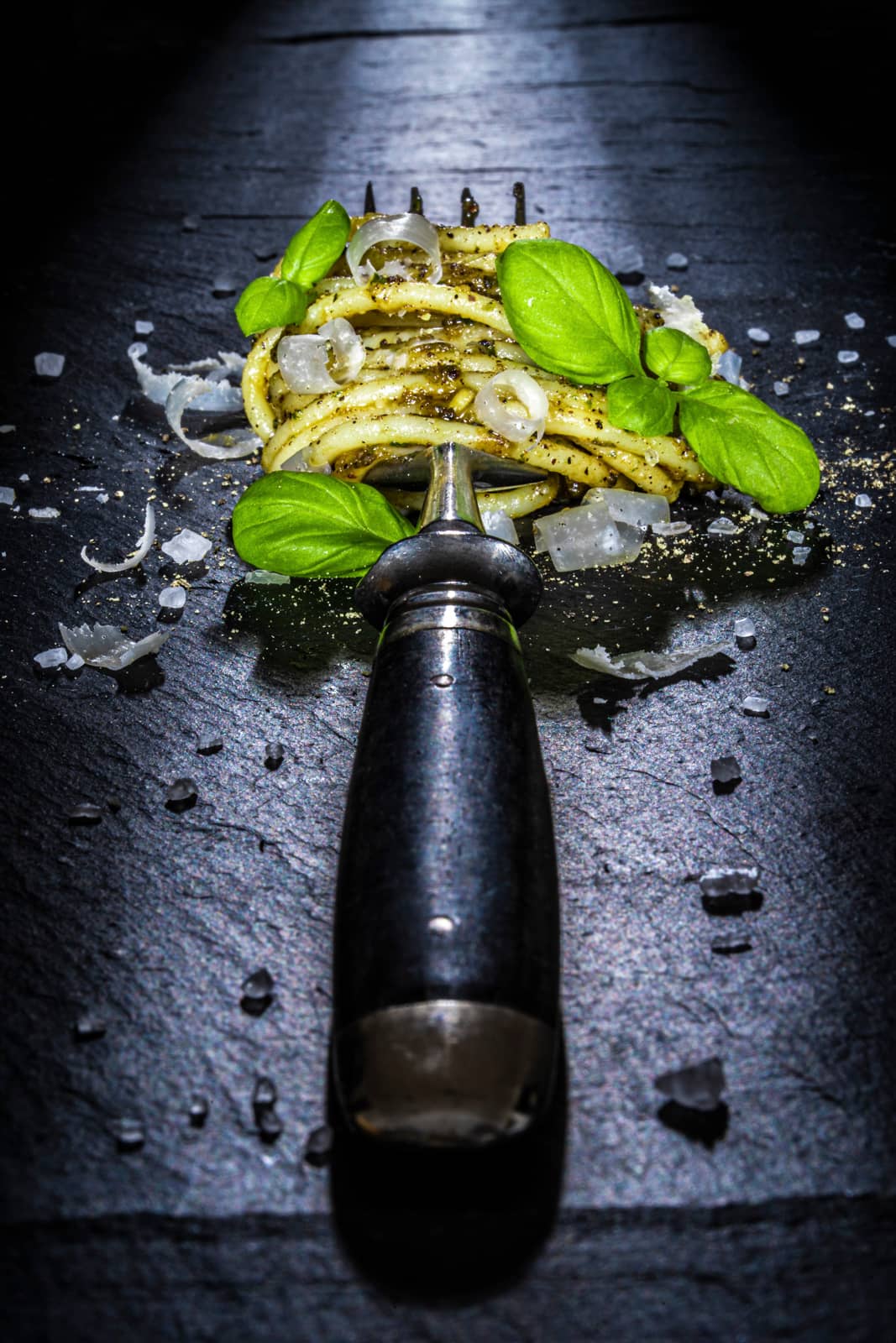 Spaghetti auf Gabel mit Pesto und Basilikum