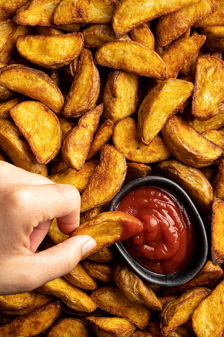 Hand dippt Kartoffel Wedges in Ketchup Food Fotograf Hessen